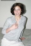 Brunette amateur Nico finger spreads her trimmed pussy after disrobing on bed