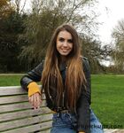 Long-haired teen in a leather jacket puts a hard dick in her mouth in a park