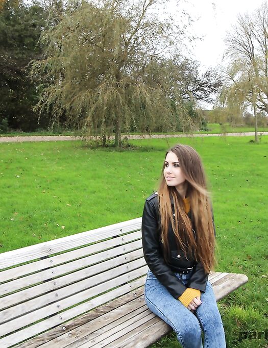 Long-haired teen in a leather jacket puts a hard dick in her mouth in a park